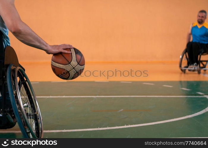 Close up photo of wheelchairs and handicapped war veterans playing basketball on the court. Selective focus . Close up photo of wheelchairs and handicapped war veterans playing basketball on the court