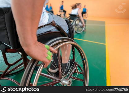 Close up photo of wheelchairs and handicapped war veterans playing basketball on the court. Selective focus . Close up photo of wheelchairs and handicapped war veterans playing basketball on the court