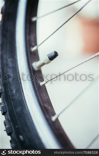 Close up picture of a bike tyre outlet and spokes, blurry background