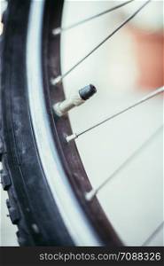 Close up picture of a bike tyre outlet and spokes, blurry background