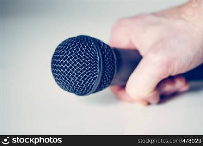 Close up picture of a black in the hand of a journalist microphone