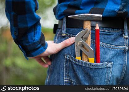 Close up picture of a craftsman with hammer, pencil and gripper in his pocket