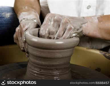 Close-up picture of a potter works a potter&acute;s wheel