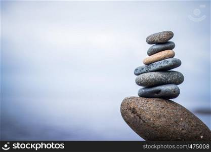 Close up picture of a stone cairn outdoors. Ocean in the blurry background