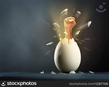 Close-up picture of broken egg with hand isolated on gray background