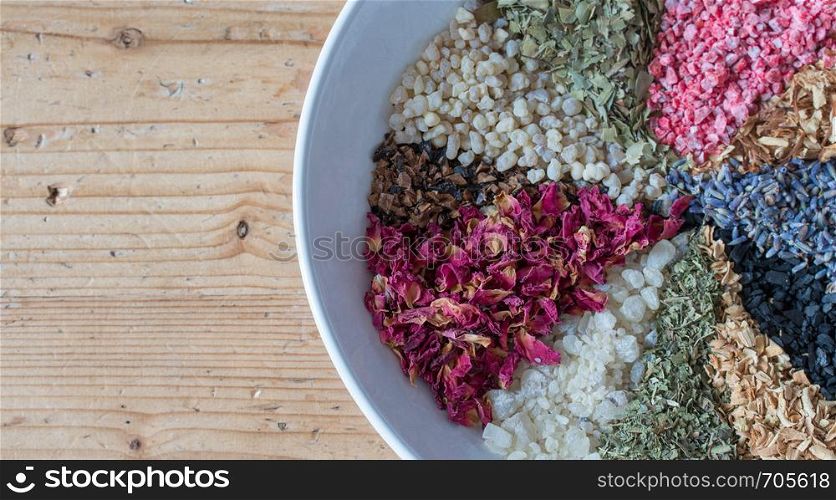 Close up picture of dried incense in a ceramic bowl, wooden background