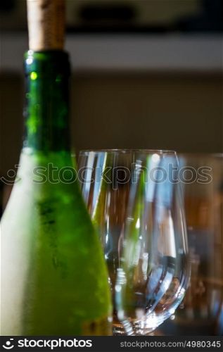 Close up picture of empty wineglasses and green bottle of wine at home