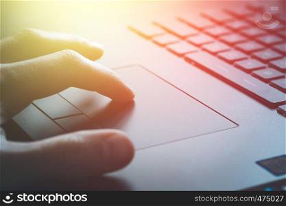 Close up picture of hands using a notebook touchpad, sunshine