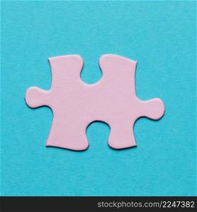 close up pink jigsaw puzzle piece blue background