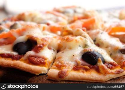 Close up pizza with ham, cheese, tomatoes and olives