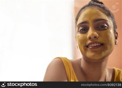 Close-up port of woman with turmeric face pack