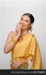 Close up, Portrait beautiful Asian woman in traditional Thai dress costume smile and use hand close her mouth with gracefully pose on white background, copy space