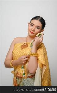 Close up, Portrait beautiful Asian woman in traditional Thai dress costume smile and holding a garland with gracefully pose on white background