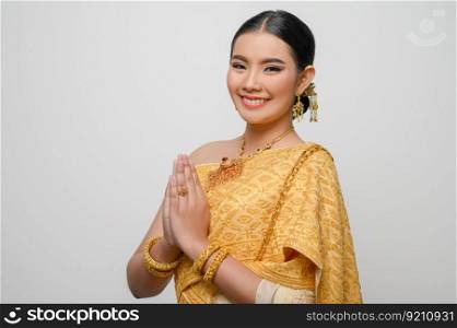 Close up, Portrait beautiful Asian woman in traditional Thai dress costume smile and pose raise hand with gracefully on white background, copy space
