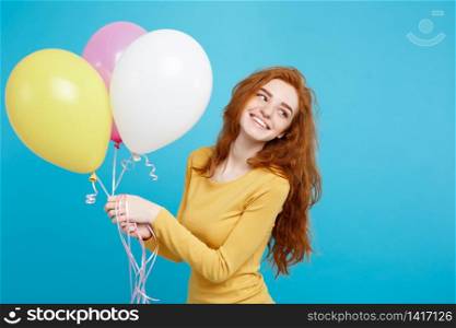 Close up Portrait happy young beautiful attractive redhair girl smiling with colorful party balloon. Blue Pastel Background.. Celebrating Concept - Close up Portrait happy young beautiful attractive redhair girl smiling with colorful party balloon. Blue Pastel Background.
