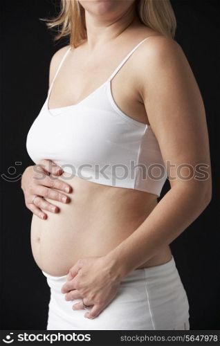 Close Up Portrait Of 4 months Pregnant Woman On Black Background