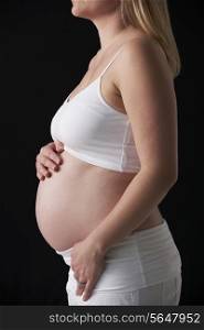 Close Up Portrait Of 5 months Pregnant Woman On Black Background