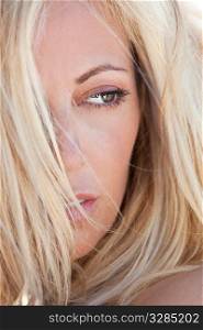 Close up portrait of a beautiful blond woman, shot outside in natural light with the focus on her eye.