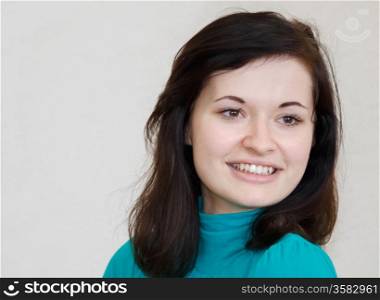 close-up portrait of a beautiful happy young cheerful brunette smiling girl in the blue sweater