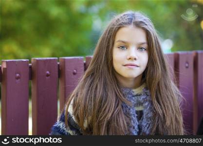 Close up portrait of a beautiful nine year old little girl in autumn park