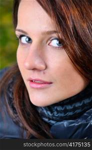 close up portrait of a beautiful young brown haired woman looking at camera from below