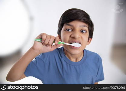 Close-up portrait of a boy brushing his teeth