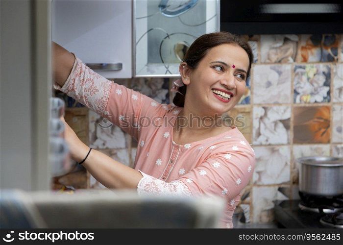 Close-up portrait of a cheerful housewife in kitchen