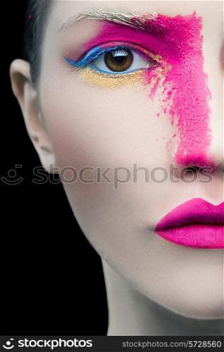 Close up portrait of a girl with pink artistic make up on black background