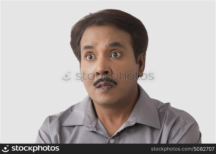 Close up portrait of a surprised man on a white background.