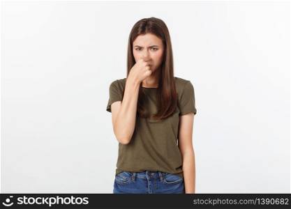 Close-up portrait of a young attractive woman who covers her nose, something stinks, isolated on white background.. Close-up portrait of a young attractive woman who covers her nose, something stinks, isolated on white background