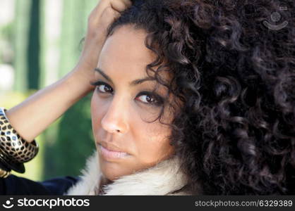 Close-up portrait of a young black woman, afro hairstyle, in urban background