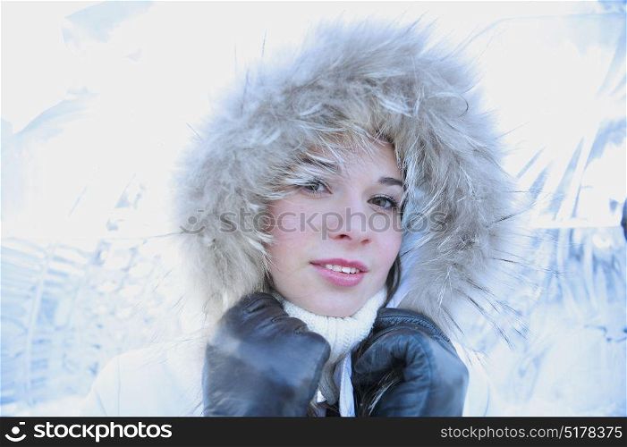Close up portrait of a young girl with ice wall. Winter concept
