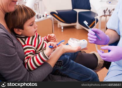 Close-up portrait of a young smiling mother and her son on reception at the dentist. Mom and her little son visiting the dentist