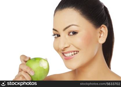 Close-up portrait of a young smiling woman holding green apple