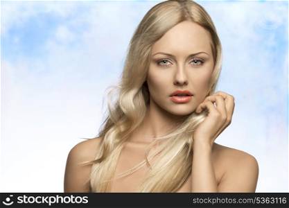 close-up portrait of alluring blonde woman with naked shoulders, pure skin and flying silky hair