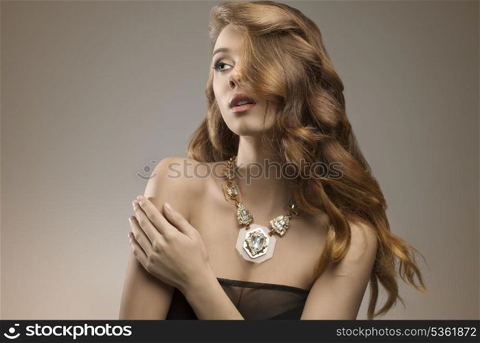 close-up portrait of attractive elegant girl with sexy dark dress, beautiful long wavy hair and big necklace. Fashion glamour shoot