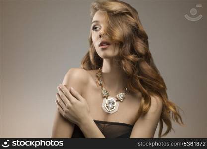 close-up portrait of attractive elegant girl with sexy dark dress, beautiful long wavy hair and big necklace. Fashion glamour shoot
