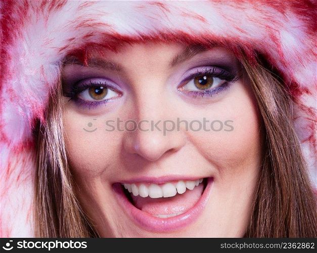 Close up portrait of attractive smiling young woman in fur winter cap with purple violet make up. Wintertime.. Woman portrait in winter cap