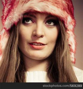 Close up portrait of attractive smiling young woman in fur winter cap in studio. Wintertime.. Woman portrait in winter cap
