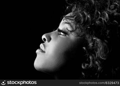Close up portrait of beautiful black woman on black background with red hair. Afro hairstyle. Studio shot