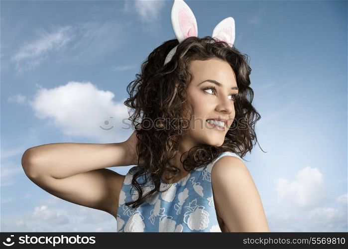 close-up portrait of beautiful brunette girl with easter funny style, pink bunny ears and lovely spring dress