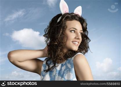 close-up portrait of beautiful brunette girl with easter funny style, pink bunny ears and lovely spring dress