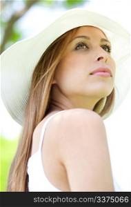 Close up portrait of beautiful female model with hat looking away