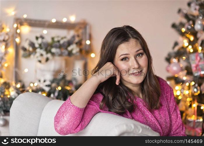 Close-up portrait of beautiful girl on the background of sparkling lights.. Girl with a beautiful face a Christmas decorations 9494.