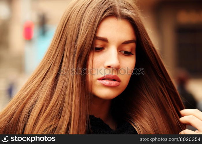 Close up portrait of beautiful girl with health long hair outdoors.