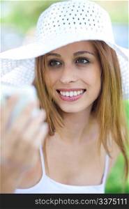 Close up portrait of beautiful smiling women with hat using mobile phone