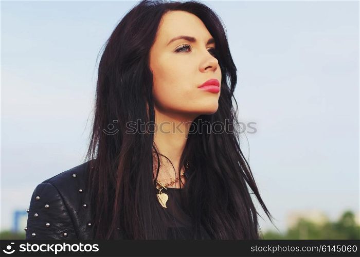 Close up portrait of beautiful woman with perfect long hairs, wearing stylish leather black jacket. Autumn retro style.