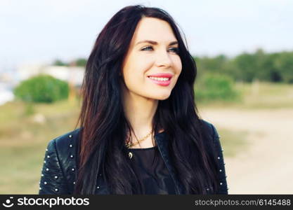 Close up portrait of beautiful woman with perfect long hairs, wearing stylish leather black jacket. Autumn retro style.