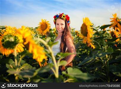 Close-up portrait of beautiful young woman at sunflower field