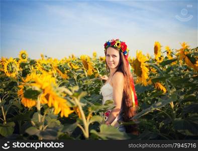 Close-up portrait of beautiful young woman at sunflower field